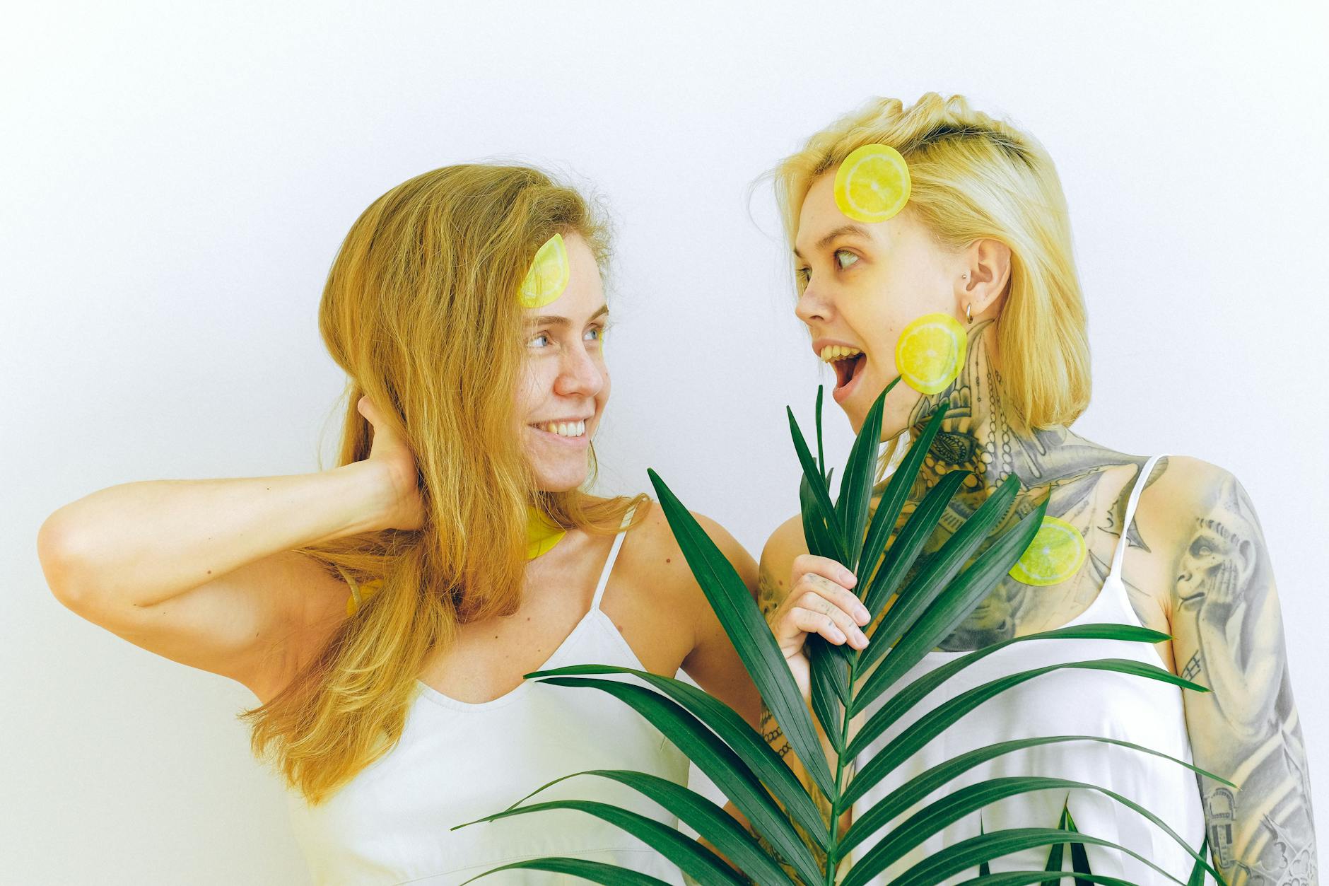 Two women smiling and laughing together indoors, expressing comfort and joy
